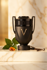 Rabanne Invictus Victory Absolu Parfum Intense - schwarzer Pokal-Flakon mit Patchouli und Vanille auf hellem Marmor - kaufenparfum.de