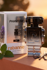 Rabanne Phantom Elixir Parfum Intense Roboter-Flakon mit Verpackung in goldenem Abendlicht mit Lavendel und Vanille - kaufenparfum.de