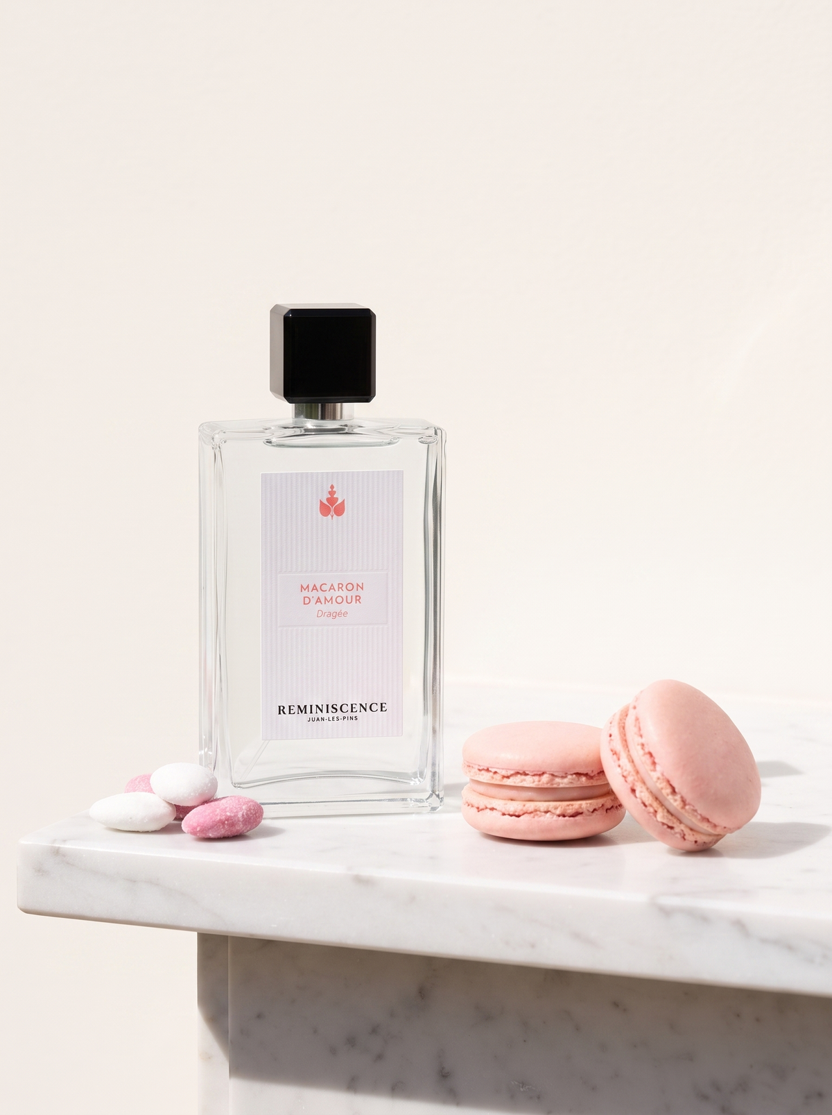 Reminiscence Macaron d'Amour Eau de Parfum 100 ml - klarer Flakon auf weissem Marmor mit rosa Macarons