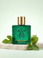 Roberto Cavalli Uomo Verde Assoluto Eau de Parfum 100 ml - gruener Flakon auf hellem Stein mit Feigenblatt und Apfel