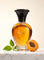 Rochas Femme Eau de Toilette 100 ml - Amphoren-Flakon auf hellem Marmor mit Aprikose