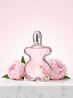 Tous LoveMe Eau de Parfum 90 ml - rosa Baerchen-Flakon auf hellem Marmor mit Pfingstrosen