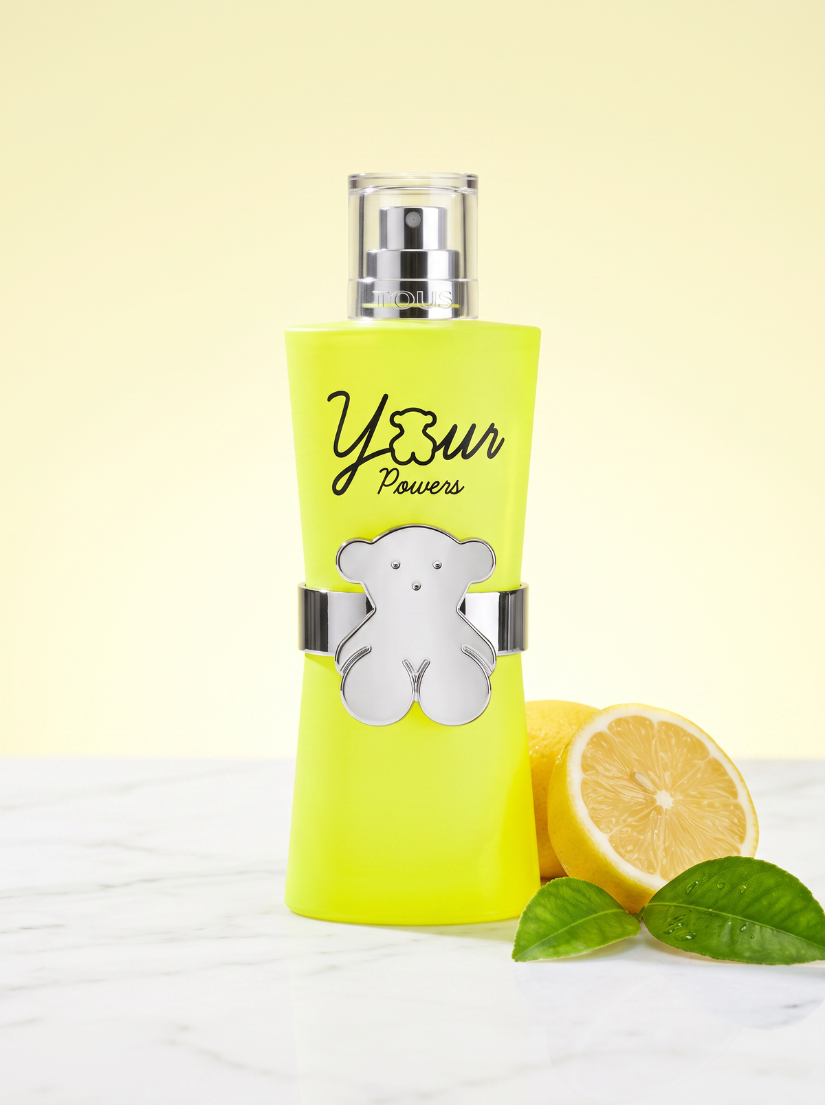 Tous Your Powers Eau de Toilette 90 ml - neongelber Flakon mit Baerchen-Emblem auf hellem Marmor mit Zitrone